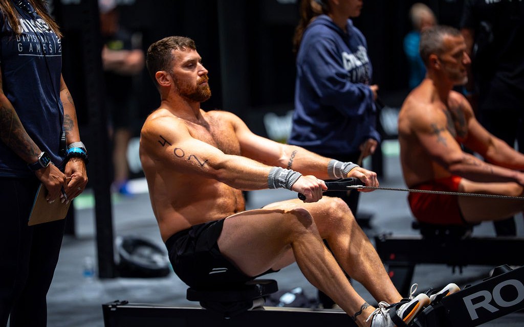 Kyle Ruth rowing on a Rogue rower on the CrossFit Games competition floor
