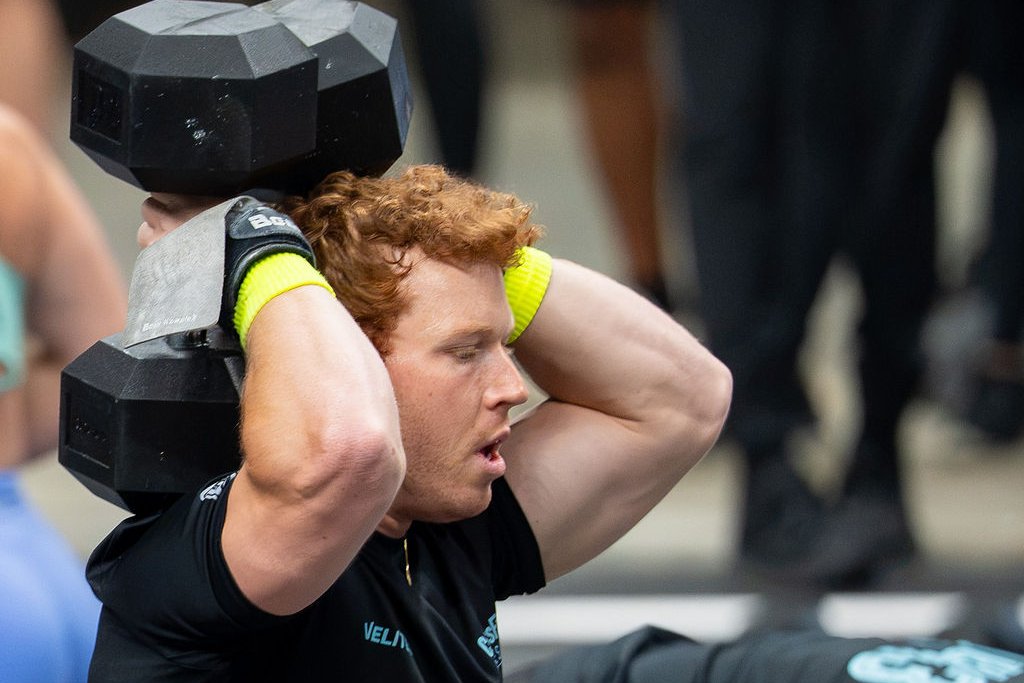 Tanner Balazas under load with two dumbbells at the 2026 CrossFit Games