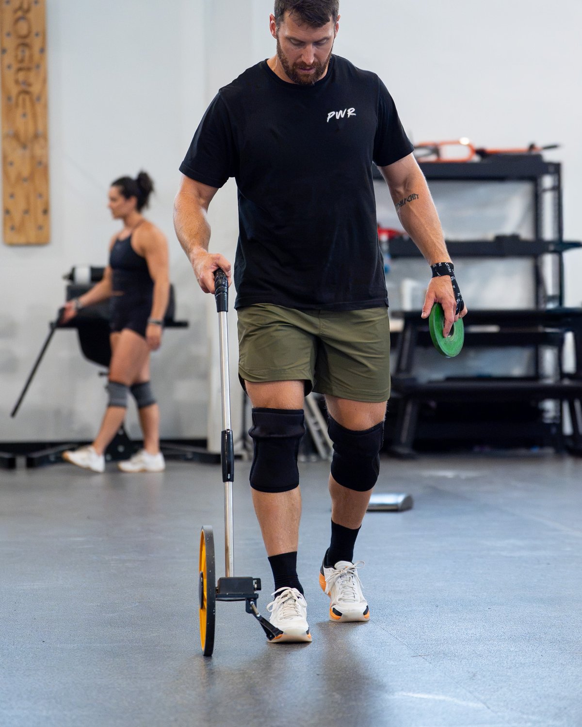 Kyle Ruth measuring a handstand walk course before an athlete's session